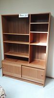 Front view of entire two-piece bookcase hutch showing open shelves above sliding door cabinets