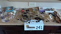 Photo of entire collection of necklaces, bracelets, clip-on earrings, and pins arranged on table.