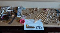 Overview of entire collection showing various necklaces, bracelets, earrings, and pins laid out on a counter