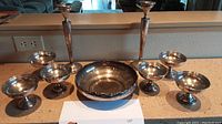 Full lot arranged on countertop: two tall candlesticks at back, six compotes around central bowl