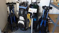 Overview of golf bags, clubs, and carts showing full lot