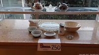 Wide angle shot showing entire kitchen and dining collection on counter, includes teapots, bowls, divided dish, creamer, shaker, small dishes