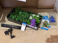 Aquarium top with assorted decorative plastic plants and instructional booklets arranged in a display.
