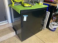 Black Arctic King freezer showing front and side view with label indicating measurements 32 x 21 x 33.5 inches.