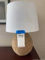 Full view of nautical rope base table lamp with beige shade showing visible stains on shade