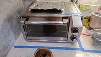 Oster toaster oven exterior with glass door, two control knobs on right side, placed on countertop