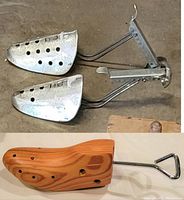 Pair of metal shoe stretchers alongside single wooden shoe stretcher with metal handle, showing full lot contents