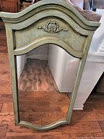 Front view of the antiqued painted dresser mirror showing curved top and decorative wood carvings with blue stain finish