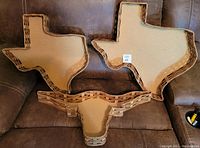 Top view showing all three baskets arranged on a couch: two Texas-shaped baskets of different sizes and one Longhorn head-shaped basket in front.