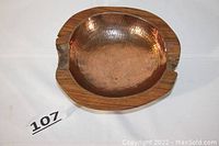 Top view of rustic teak bowl featuring shiny hammered copper center inlay, showing natural wood grain and irregular edge details.