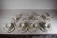 Overview of all four place settings showing dinner plate, salad plate, bread plate, teacup with saucer, demitasse cup with saucer, and soup bowl with saucer.