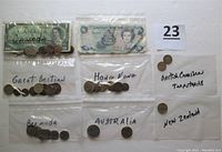 Coins and paper money placed in labeled plastic bags for each country/territory: Canada with coins and banknote, Great Britain coins, Hong Kong coins, British Caribbean Territories coins, Bermuda coins, Australia coins, New Zealand coin, and Cayman Islands one-dollar paper money.