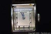 Close-up photo of the rectangular watch face showing silver dial, Hamilton logo, and hour markers.