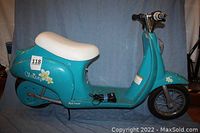 Side view of blue Razor electric scooter with white seat and floral decals, showing overall condition and size.