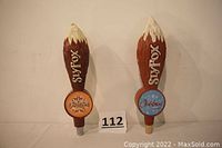 Two Sly Fox Brewing Company resin tap handles upright side by side on a white background showing the Oktoberfest and Christmas Ale labels.