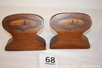 Front view of both bookends showing the hand-carved mountain and western scenes inlaid on the wood surfaces.