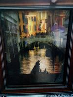 Framed photograph showing a Venice canal with a gondola and buildings, backlit with silhouette effect.