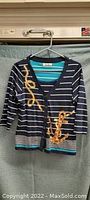 Navy blue and white striped sweater with yellow text and anchor designs front view