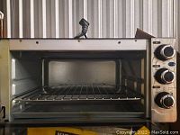 Front view of the toaster oven showing glass door and control dials.