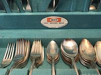 Close-up photo of various forks and spoons showing the design and detail of the silver plated cutlery.