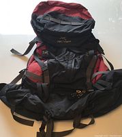 Full view of black and red Arc'teryx Bora 80 litre backpack showing multiple compression straps and compartments.