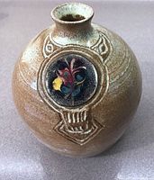 Front view of the rounded pottery vase showcasing the colorful enamelled medallion design and textured pottery surface.