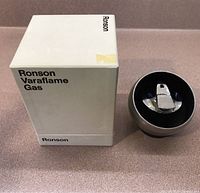 Photo of the Ronson Varaflame gas lighter in original box, showing white box with Ronson branding and the lighter beside it.