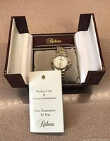 Full view of Rideau watch in original burgundy Rideau box with product care and owner information booklet included