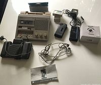 Complete transcription and dictation equipment laid out on table including Philips 505 machine, foot pedal, headphones, power supply, micro cassette tapes, two micro cassette recorders, and manual.
