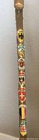 Close-up photo of top portion of the cane showing six badges with German and Swiss crests and heraldry.