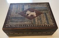 Top view of the vintage wooden box showing the inlaid Scotty dogs motif inside a diamond shape with intricate geometric borders.