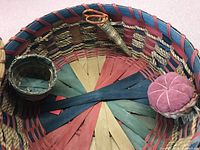 Close-up of interior showing colorful woven pattern with pin cushion and small woven basket insert