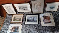 All 7 framed art prints and 1 watercolor arranged on floor against baseboard