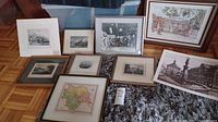 Wide view of all framed prints on floor showing assortment of maps and architectural prints