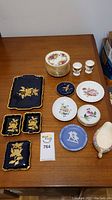 Overview of assorted porcelain dishes on wooden surface including plates, trays, bowl, and egg holders.