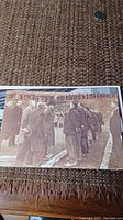 Sepia toned postcard on woven surface showing King Edward VIII and several men lined up outdoors.
