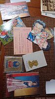 Overview of assorted Royal Family themed puzzles, postcards, tickets, and pamphlets arranged on a woven mat