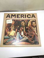 Front cover of the America vinyl LP album with band artwork and name.