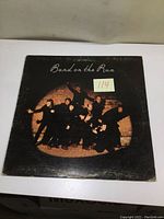 Front cover of Band on the Run vinyl record showing Paul McCartney and Wings posing with dramatic shadows and a black background.