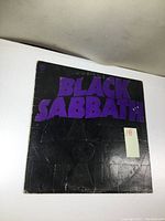 Front cover of Black Sabbath Master of Reality vinyl LP showing purple lettering and visible wear.