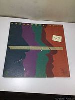 Front cover of the Creedence Gold album showing colorful silhouette art and visible wear and peeling along bottom left corner.