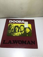 Front cover of The Doors L.A. Woman album showing band photo and album title.