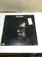 Front cover of the Elton John vinyl album showing a close-up portrait with notable wear and surface scratches.
