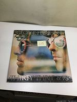Front cover of the George Harrison Thirty Three & 1/3 vinyl album showing profile of artist wearing reflective sunglasses and album title.