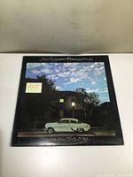 Front cover of the vinyl album showing the vintage car and cloudy sky scene.