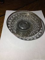 Top angle view showing the intricate lattice work and monogrammed center of the sterling silver dish.