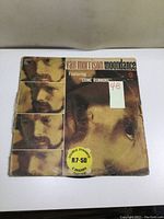 Front cover of Van Morrison Moondance album with wear and creases, featuring four images of Van Morrison's face and a price sticker.