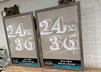 Two 24x36 inch Belmont picture frames with dimension labels, wood grain finish, standing upright showing front face.