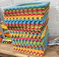 Stacked colorful interlocking foam mats showing the colors and thickness