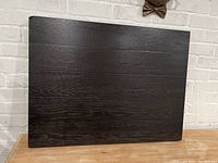Front view of the rectangular dark wood table top with visible wood grain and a smooth surface.
